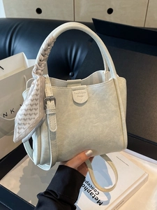 Chic cream white bucket bag with silk scarf handle and fashionable pebble leather texture
