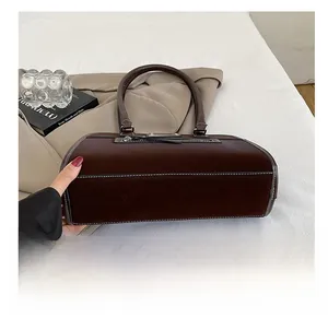Vue détaillée du fond du sac Boston marron foncé avec surpiqûres blanches contrastées