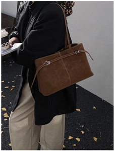 Detail of vintage brown suede tote bag with minimalist stitching and slim leather straps