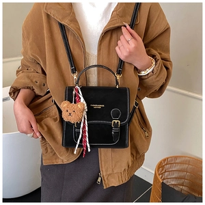 Detail of matte black versatile bag with cute bear charm and fashion text print