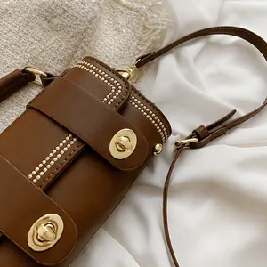 Details van het bruine lederen oppervlak met gouden studs en metalen draaisluiting