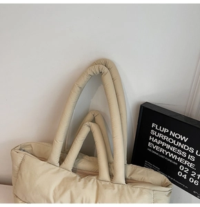 Gros plan détaillé du sac cabas matelassé crème avec texture bouffante et fermeture éclair