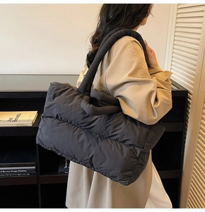Sac fourre-tout noir matelassé avec bandoulière rembourrée porté par un mannequin