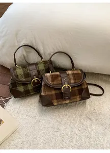 Detail of wool fabric and leather patchwork on vintage plaid handbags with metal buckles