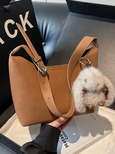 Borsa a secchiello in pelle marrone con tracolla regolabile e ciondolo a forma di coniglio