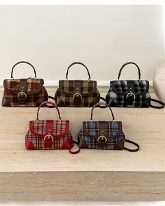 Detail view of five retro plaid crossbody bags displayed on stone steps for winter fashion