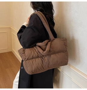 Vue détaillée latérale d'un grand sac cabas matelassé marron avec bandoulière rembourrée