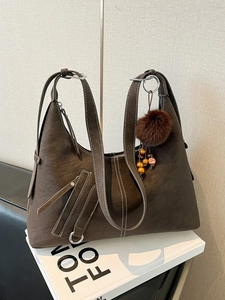 Vintage brown shoulder bag with white stitching and decorative faux fur pompom charm