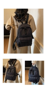 Détails du sac à dos matelassé noir avec texture rembourrée et poche avant zippée pratique