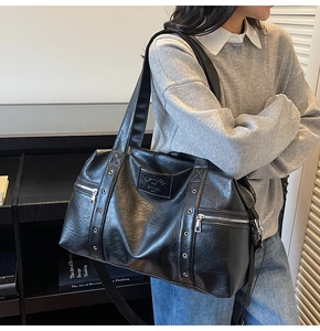 Détail du grand sac cabas vintage noir avec œillets métalliques et zips latéraux