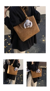 Macro view of brown suede tote bag featuring a cute grey plush rabbit pendant accessory