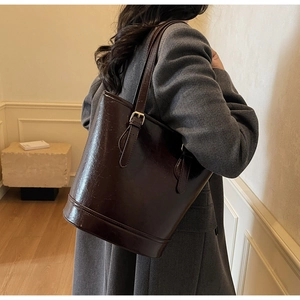 Retro deep brown glossy leather tote bag with adjustable strap and golden metal hardware