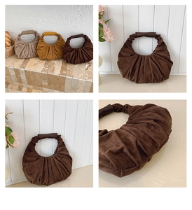 Detailed view of pleated suede crescent handbag texture with smooth leather handle