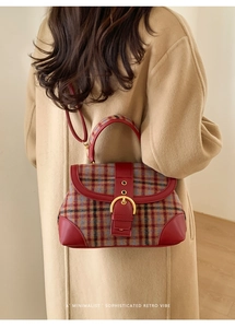 Detail of a retro plaid handbag with red leather trim and a gold metallic buckle