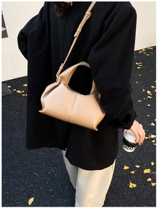 Vue détaillée du sac bandoulière en cuir beige grainé avec une texture plissée souple