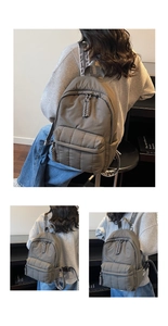 Détails du sac à dos en nylon matelassé gris avec sangles lettrées et zips tissés