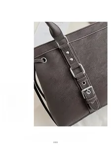 Dettaglio ravvicinato della borsa tote taupe in pelle martellata con borchie argento