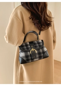 Detail of vintage plaid handbag with wool fabric texture and gold horseshoe buckle