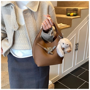 Detail of brown pebbled leather hobo bag with silver buckle and plush rabbit charm