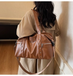 Détail du grand sac cabas en similicuir marron avec œillets métalliques et bandoulière
