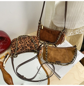 Detail of suede crossbody bags featuring leopard print and charms with gold chain accents