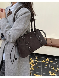 Dettaglio della borsa tote vintage marrone scuro con fibbie e pelle opaca