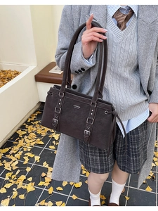 Dettaglio della borsa tote in pelle opaca testa di moro con cinturini e fibbie metalliche