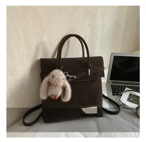 Detail show of retro dark brown backpack with silver buckle and plush bunny charm