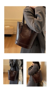 Macro detail of dark brown retro leather texture and golden metal buckle on tote bag