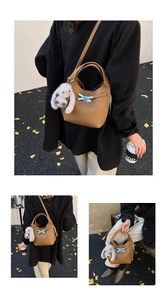 Brown leather bucket bag detail with plush rabbit charm and silver metal buckle