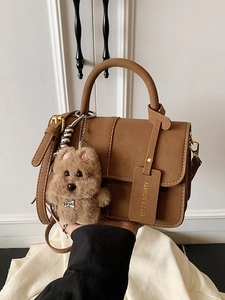 Schicke braune Handtasche aus Kunstleder mit Schultergurt und süßem Plüschhund-Anhänger