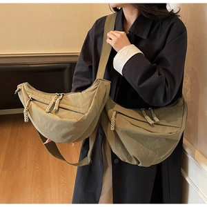 Detailed close-up of large nylon crescent bags in olive green and khaki colors