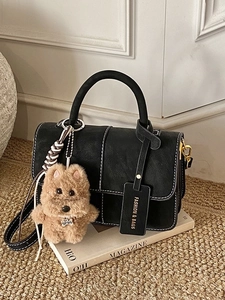 Modische schwarze Handtasche mit Kontrastnaht und braunem Plüschbär-Anhänger