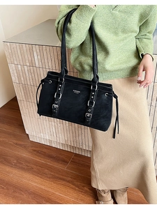 Dettaglio della borsa tote in pelle nera con fibbie argentate e scritte logo di moda