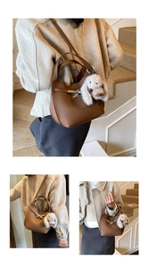 Detail of brown lychee grain leather bucket bag featuring a plush bunny charm and clasp
