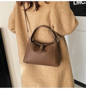 Detail view of brown lychee grain leather underarm bag with lindy style flap and strap