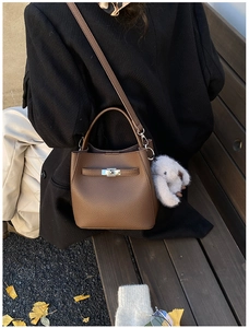 Brown lychee leather bucket bag with silver twist lock and plush rabbit charm detail