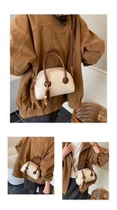 Détail d'un sac Boston rétro crème avec poignées marron foncé et breloque perlée