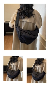 Close-up of a black crescent crossbody bag worn with a beige trench coat for a casual look