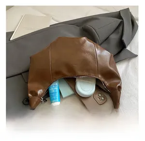 Detailansicht der braunen Leder-Halbmondtasche mit geräumigem Innenraum für Alltagsutensilien
