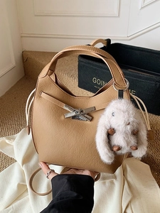 Khaki pebbled leather bucket bag with silver buckle and white plush bunny charm