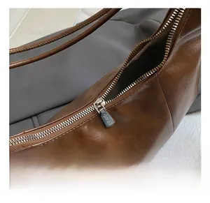 Makro-Detail des Metallreißverschlusses und dunkelbraunes Leder der Dumpling-Tasche