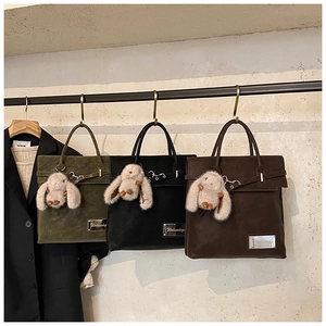Three vintage suede tote bags in green, black, and brown with cute bunny charms