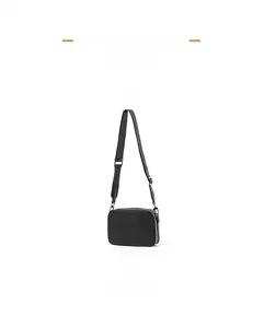 Close-up of a black rectangular crossbody bag with adjustable wide nylon shoulder strap