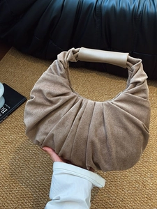 Retro pleated beige suede tote bag with smooth leather handle shown held by hand