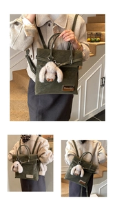 Detail of dark green suede backpack with plush rabbit charm and metal logo plaque