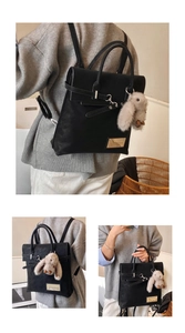 Detail of black faux leather backpack with gold metal plate and plush rabbit charm