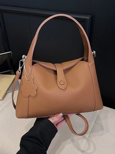 Vintage brown lychee grain leather underarm bag with a decorative flower charm