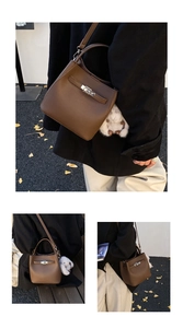 Close-up of brown pebbled leather bucket bag with silver buckle and rabbit charm