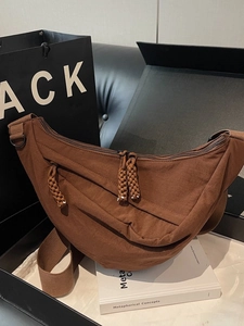 Brown casual half-moon crossbody bag with woven zipper puller in a stylish gift box